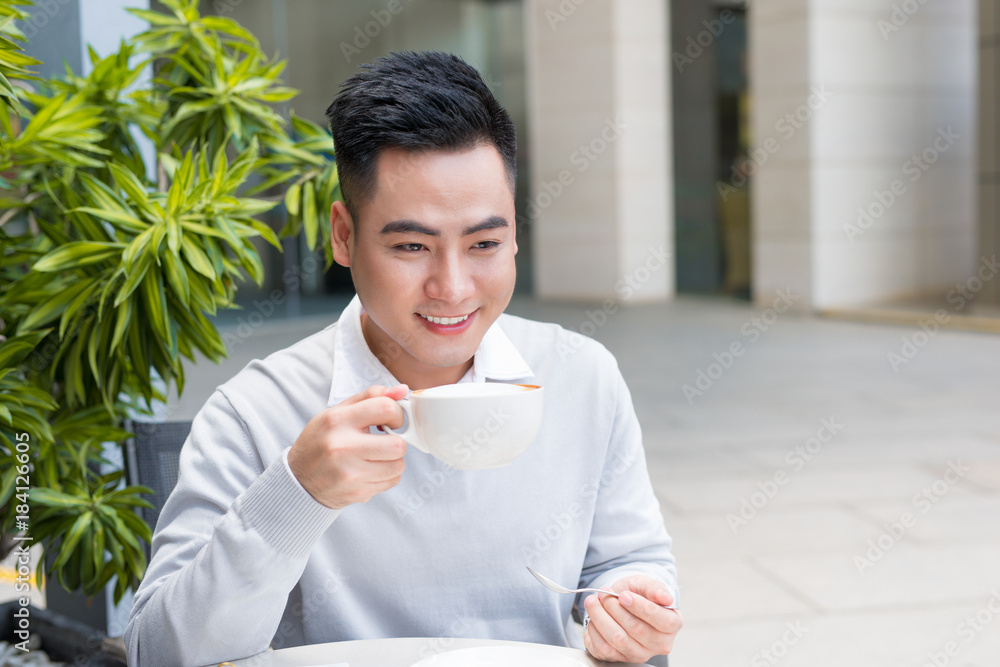 Young man sitting in a cafe on a coffee break.