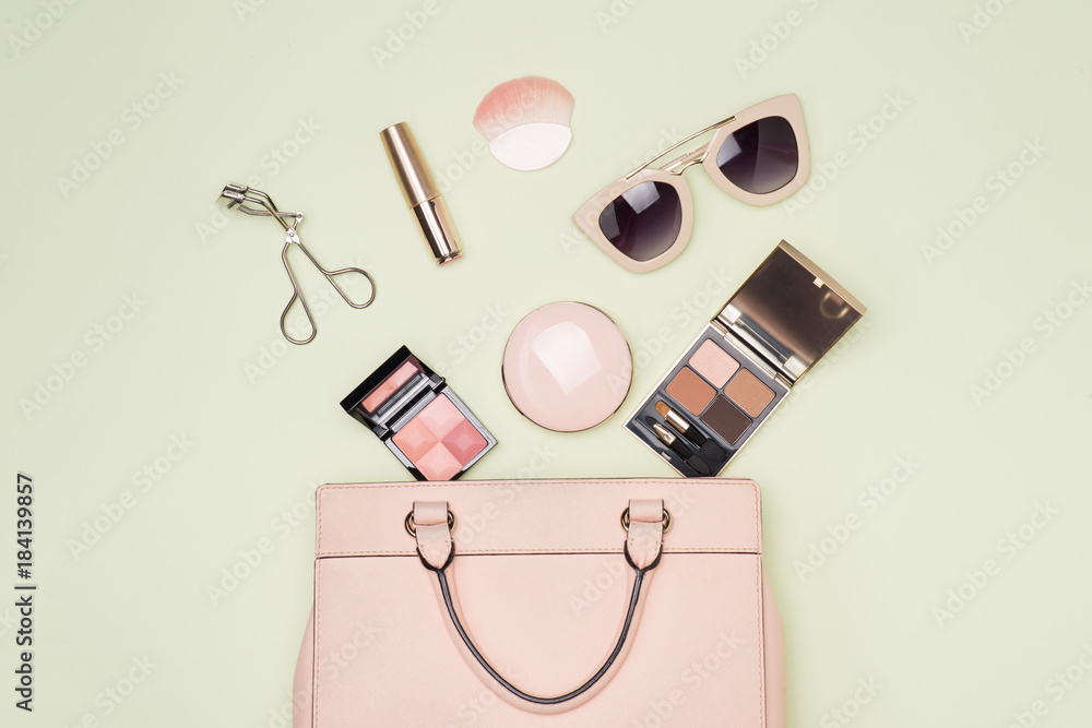 Makeup products with cosmetic bag on color background