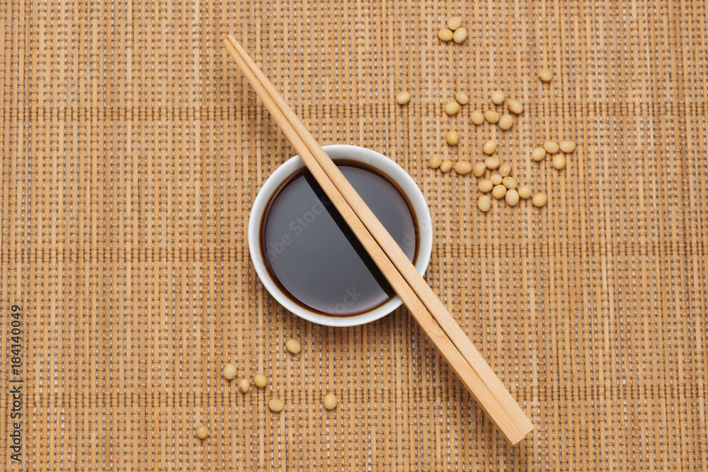 Soy sauce and soy bean with chopsticks on wooden table