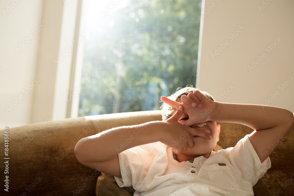 Little boy peeking through his fingers