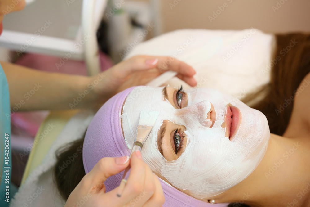 Cosmetologist applying facial mask in beauty salon. Skin care. Beauty treatment.