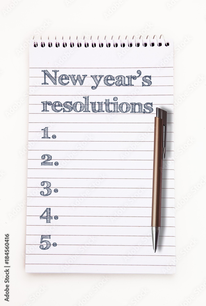 Top View of new years resolution written  on notepad