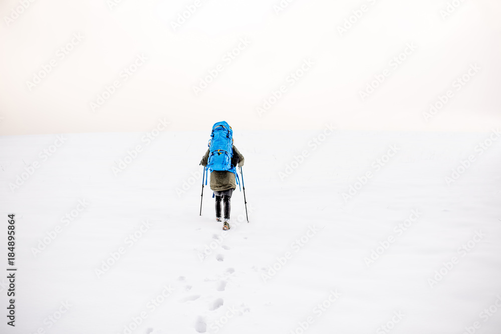 雪山上有脚印，徒步旅行者背着背包在山上行走