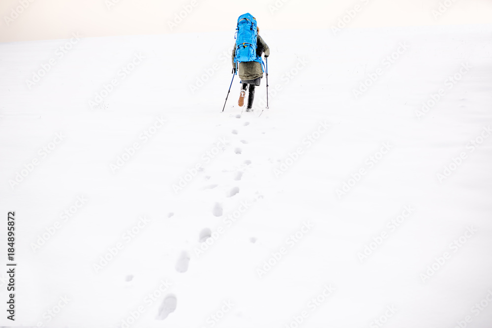 雪山上有脚印，徒步旅行者背着背包在山上行走