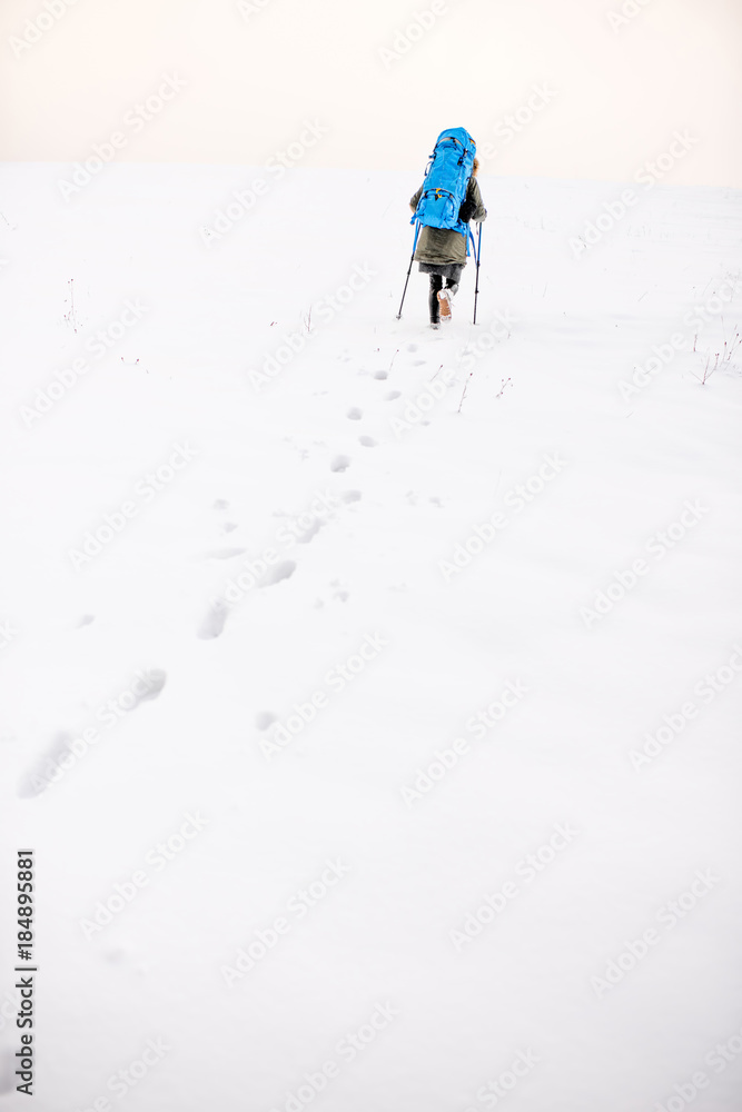 雪山上有脚印，徒步旅行者背着背包在山上行走