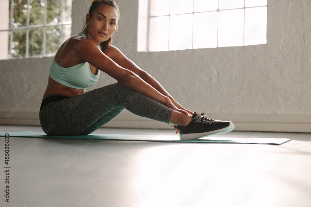 Healthy woman taking break after workout in gym