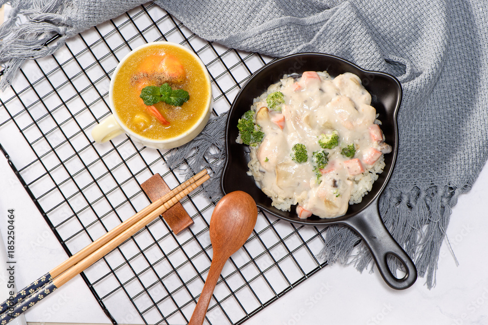 stewed chicken and rice in cream and corn soup with shrimp on a white table