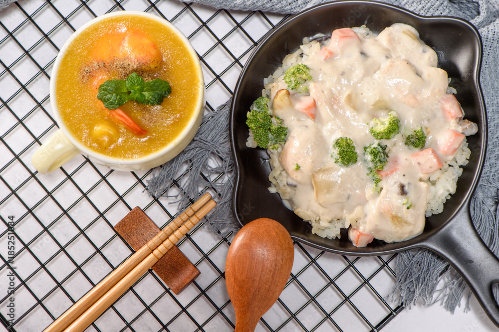 stewed chicken and rice in cream and corn soup with shrimp on a white table