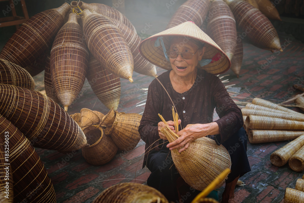 Vietnamese fishermen are doing basketry for fishing equipment at morning in Thu Sy Village, Vietnam.