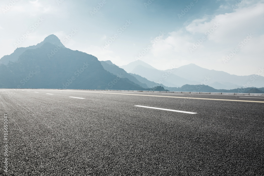 雾天山地沥青公路景观