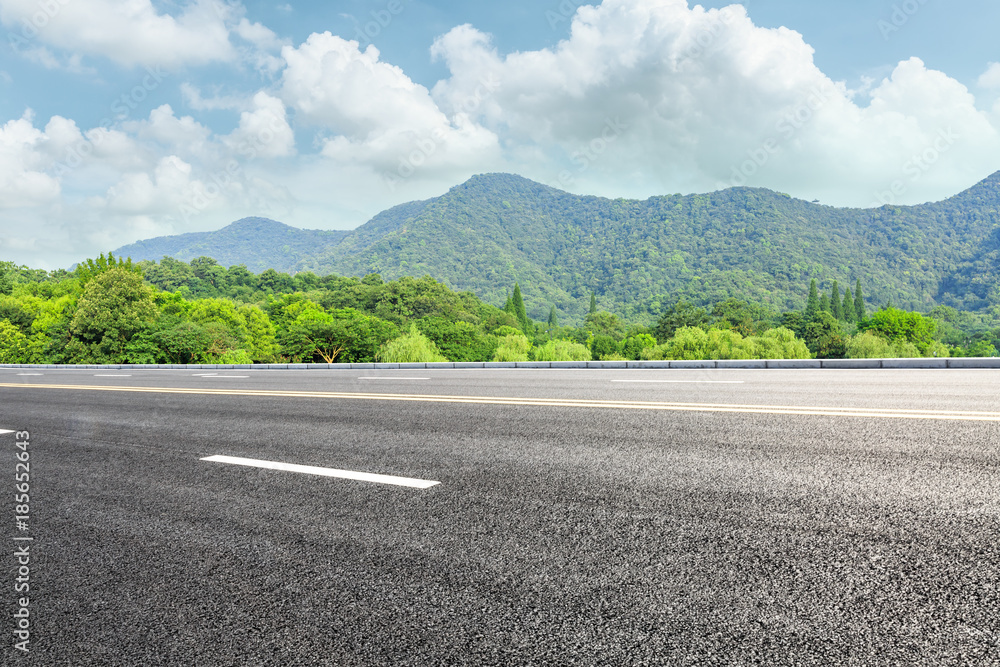 green mountain and empty asphalt highway natural scenery under the blue sky