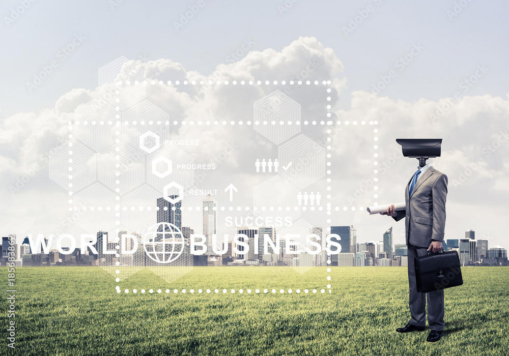 Camera headed man standing on green grass against modern citysca