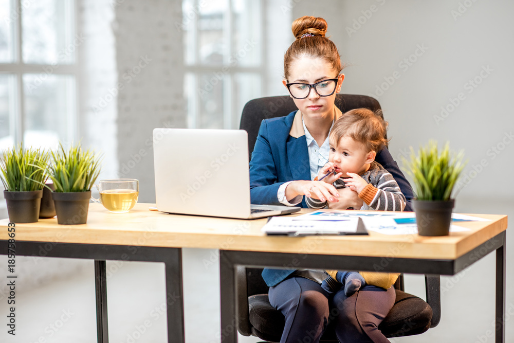 Young multitasking businessmam dressed in the suit working with laptop and documents sitting with he