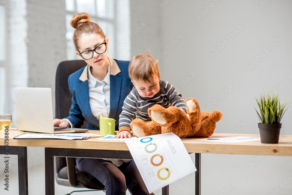 Young multitasking businessmam dressed in the suit working with laptop and documents sitting with he