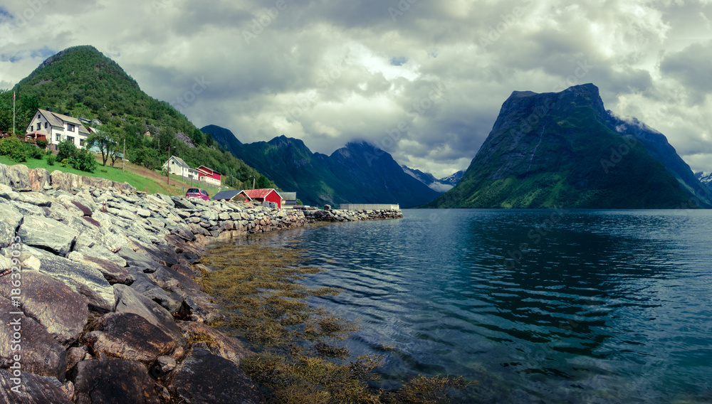 挪威乌尔克村和Hjorundfjorden峡湾的如画景色。壮观的天空和昏暗的山脉