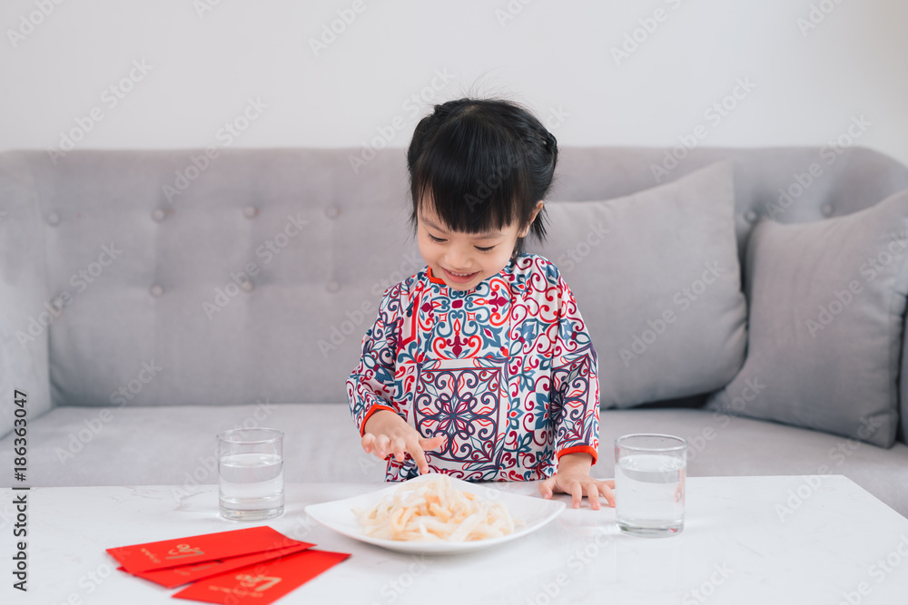 越南小女孩穿着敖岱传统服饰，在家庆祝新年。春节。