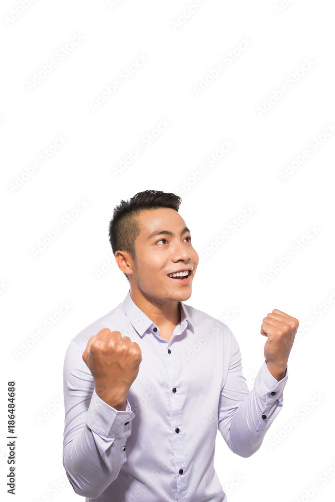 Portrait of an asian excited casual man standing with raised hands