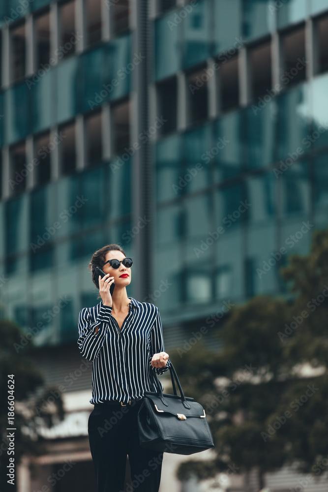 亚洲女人拿着手机走在街上