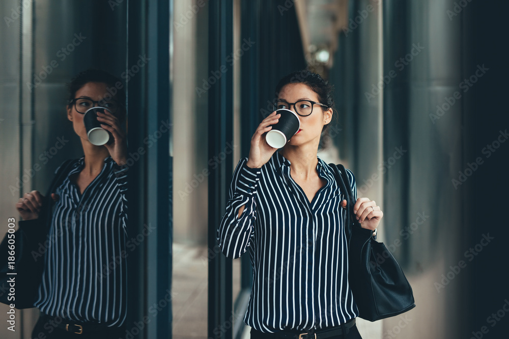 Woman outside business center drinking coffee