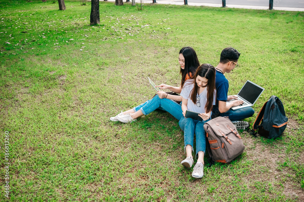 一群年轻或十几岁的亚洲学生在大学里微笑着读着书，看着ta