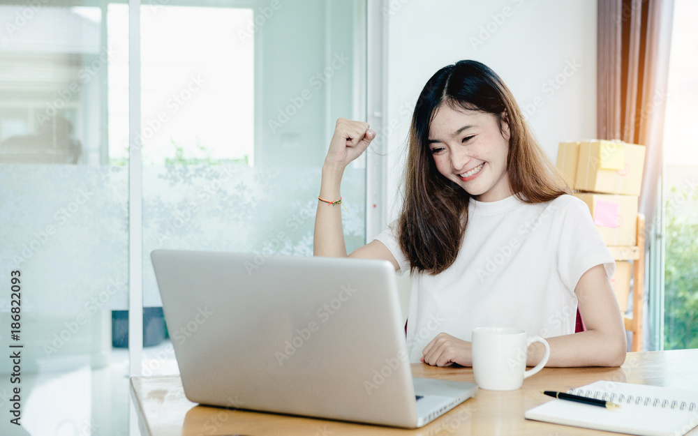 年轻的亚洲女孩是一名自由职业者，她的私人企业在家办公，用笔记本电脑和咖啡工作