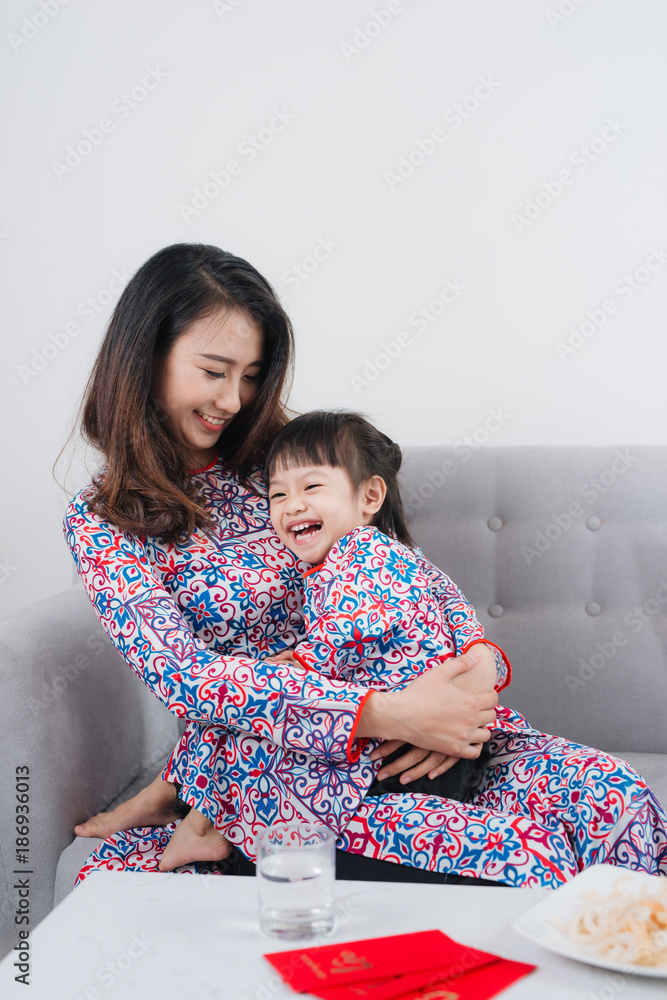 越南母亲和女儿在家庆祝新年。春节。