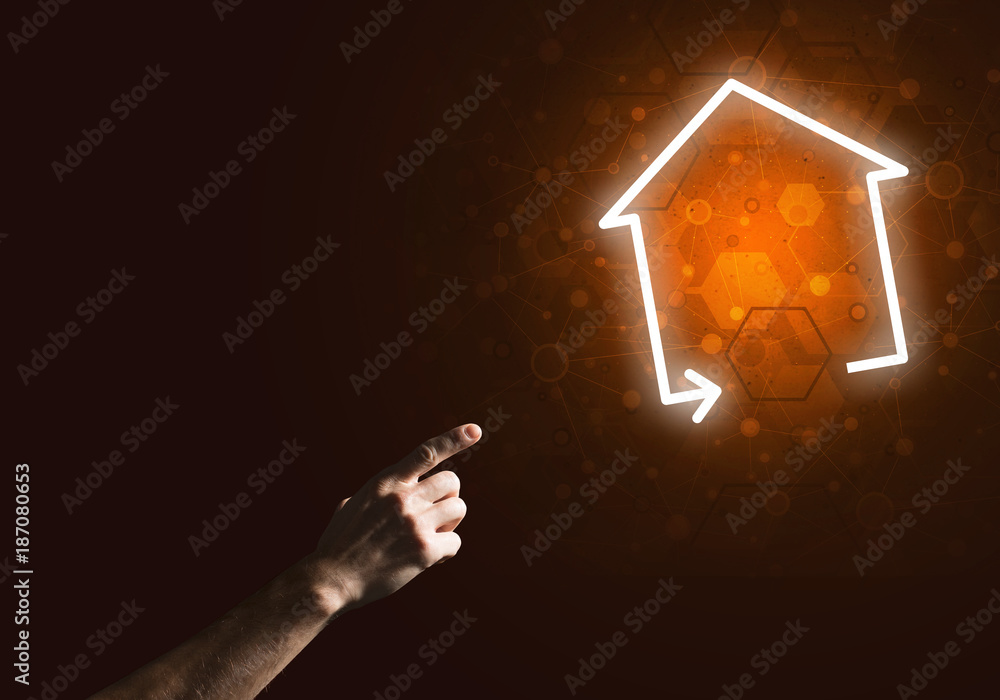 Conceptual image with hand pointing at house or main page icon on dark background