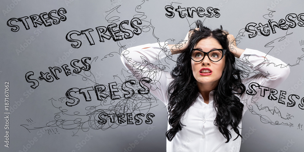 Young woman feeling stressed on a gray background