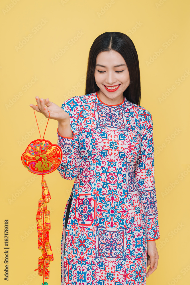 Attractive Vietnamese woman wearing traditional costume, isolated on yellow background