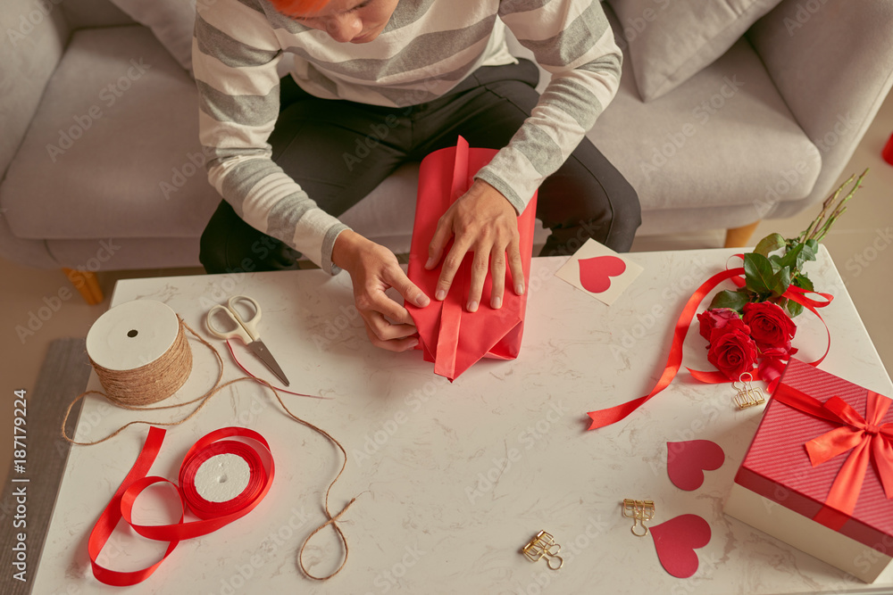 Handsome romantic guy making present for his soul mate