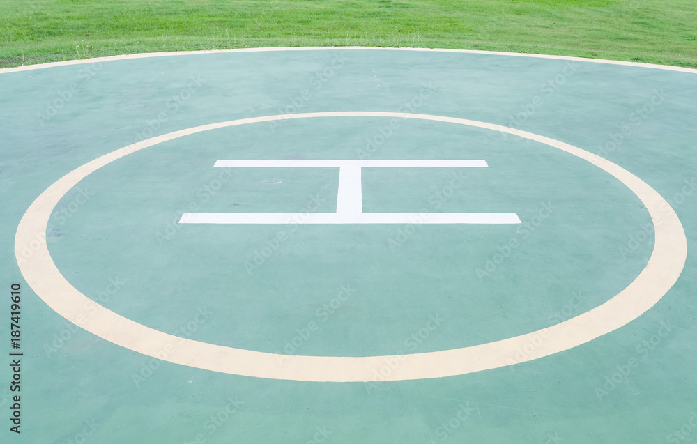 Close - up empty helipad and green grass