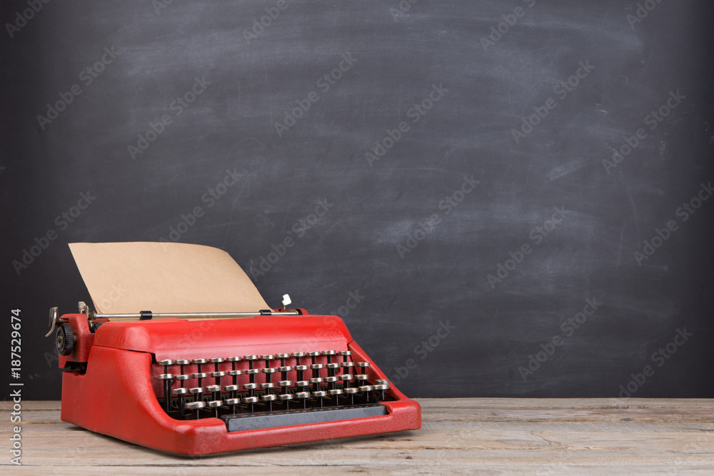 Typewriter on the blackboard background - blogging and writing concept