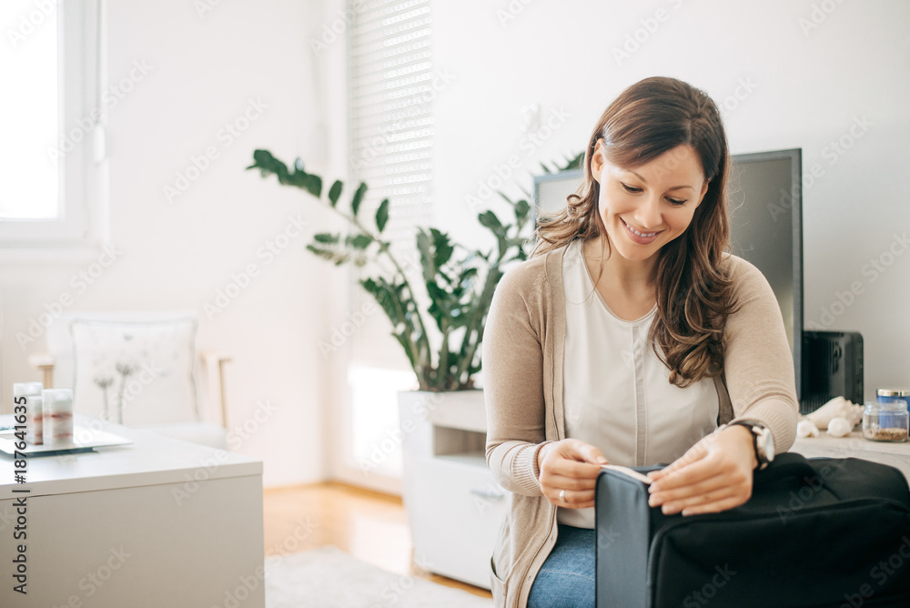 Woman at home measuring luggage before going on holiday vacation.