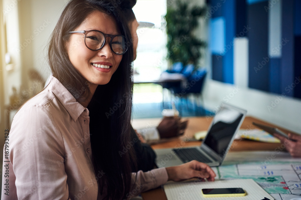 Asian businesswoman smiling during a boardroom meeting in an office