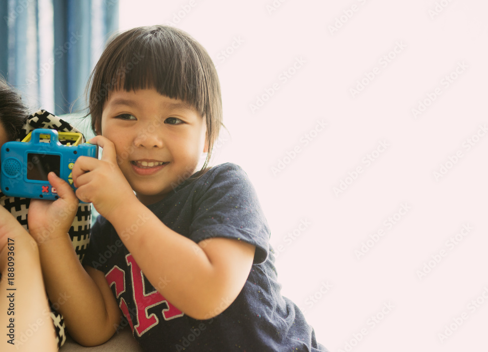 可爱的小女孩拿着一台旧相机。孩子在老式相机上拍照