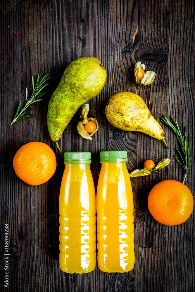 plastic bottles with fruit drinks on wooden background top view 