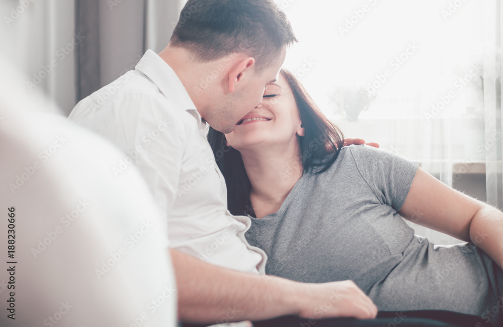 Cheerful pregnant couple relaxing at home and enjoying pregnancy time