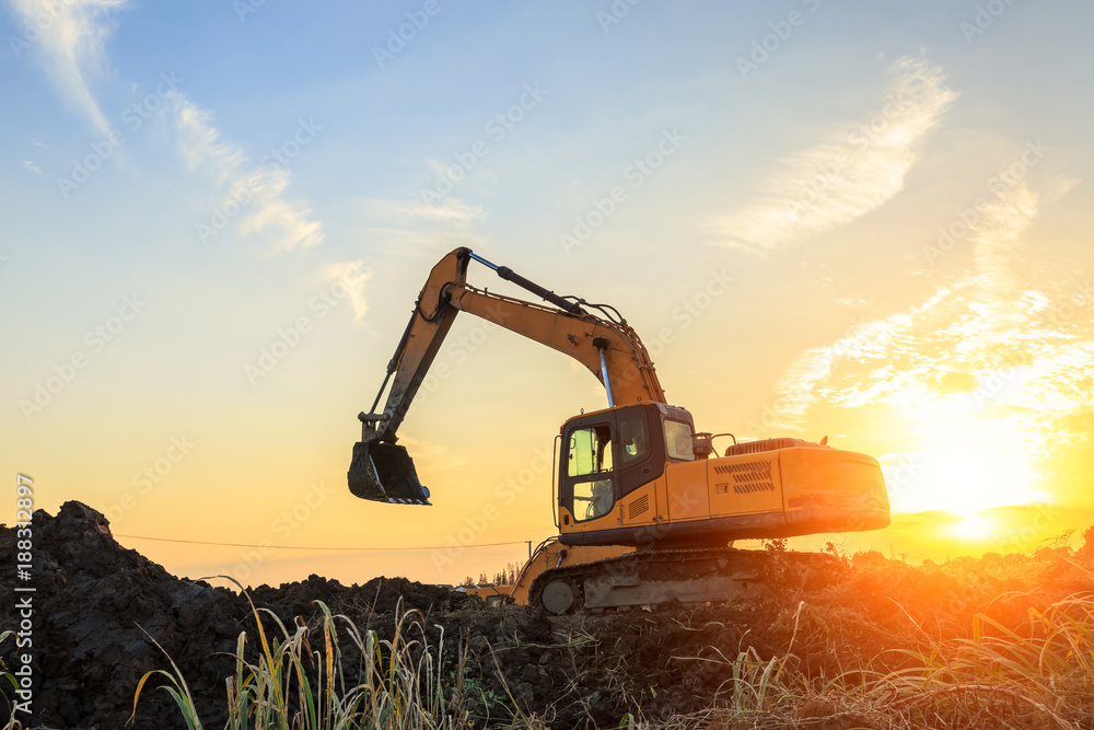 excavator working on construction site and sunrise landscape