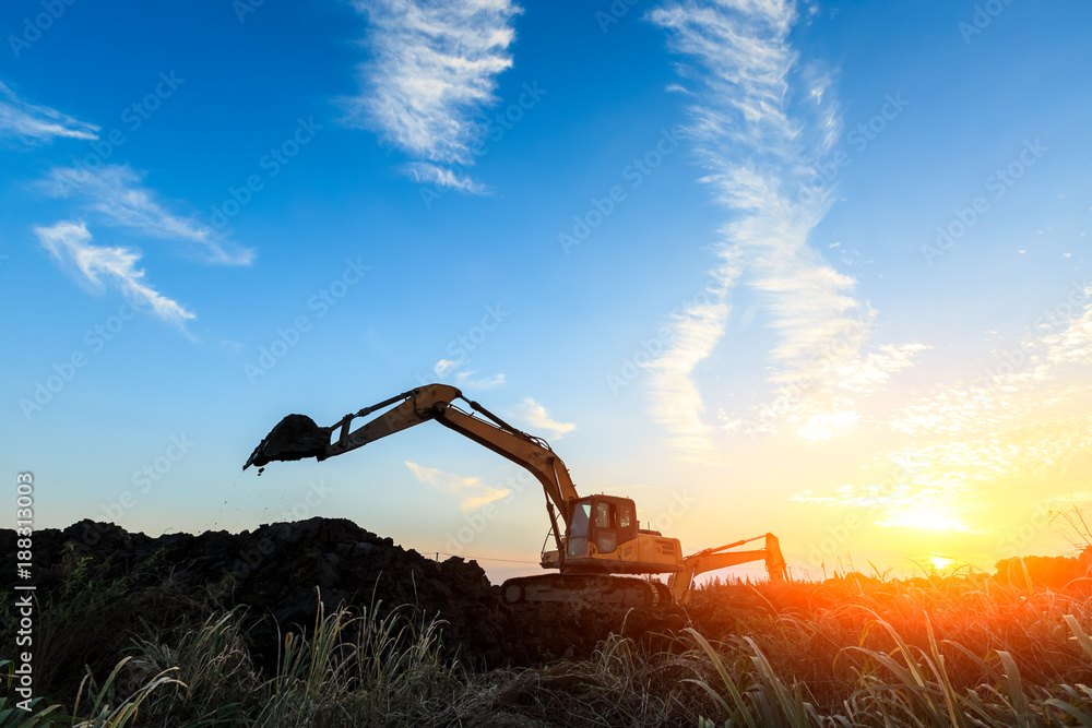 excavator working on construction site and sunrise landscape