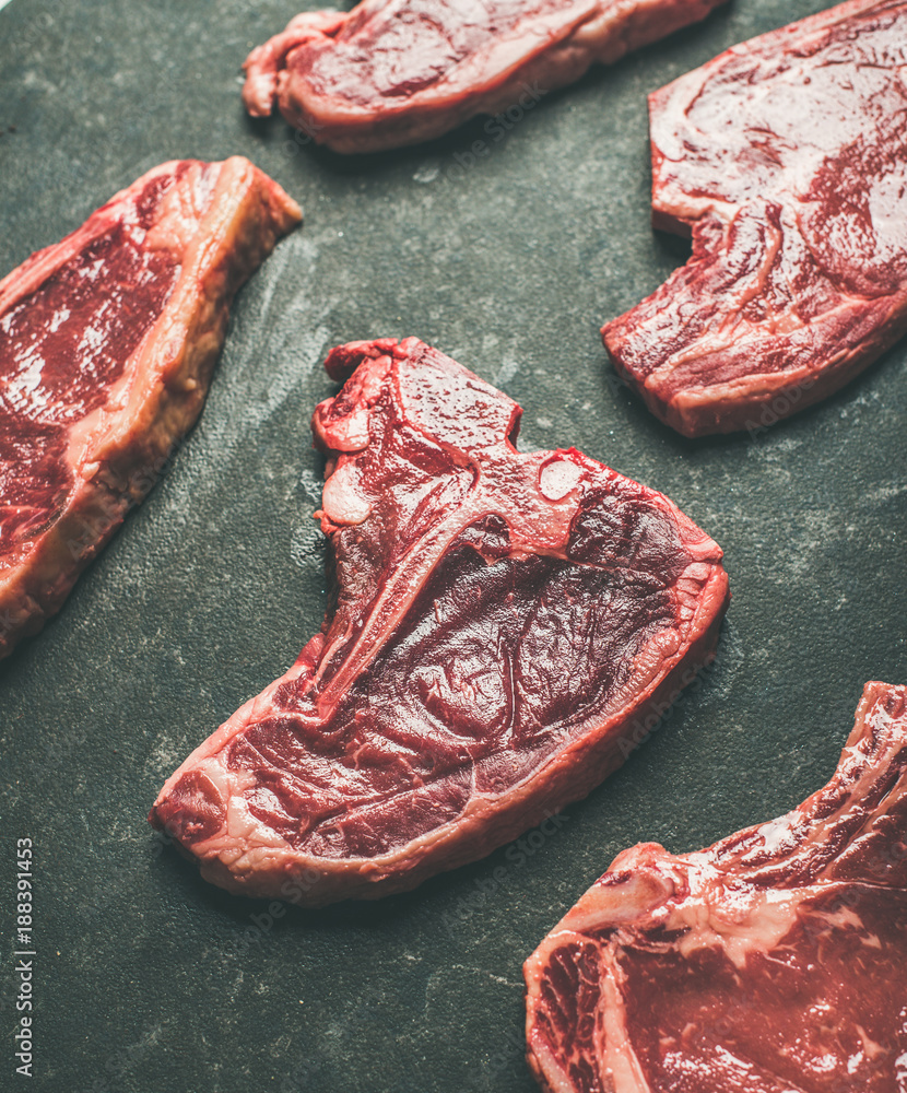 黑色石头背景下的新鲜生生牛肉牛排，选择性聚焦。Porterhouse，t