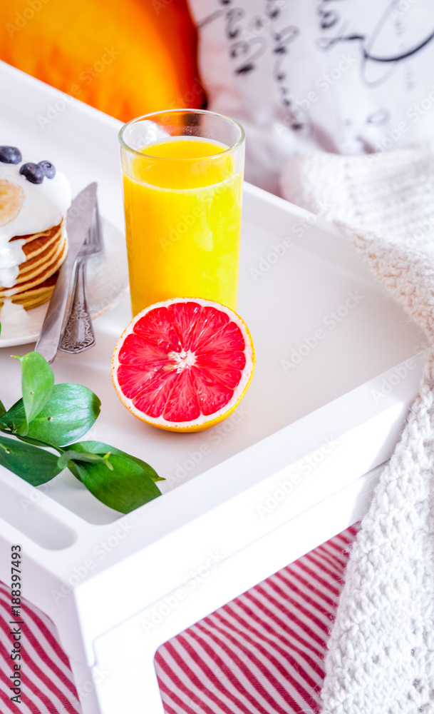 concept of breakfast in bed on tray with juice