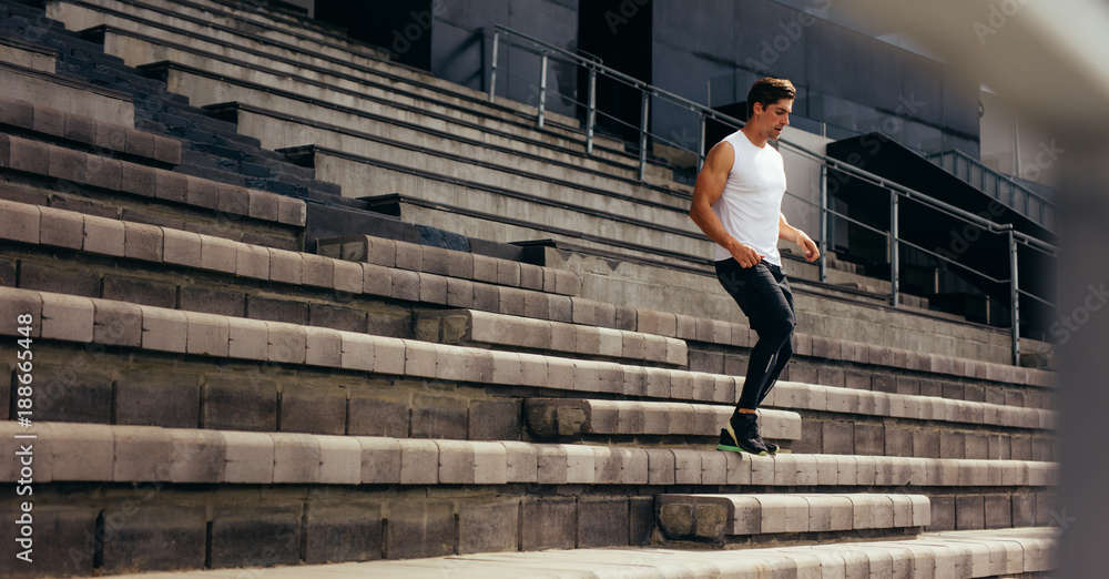 Athlete running down the stairs of a stadium stand