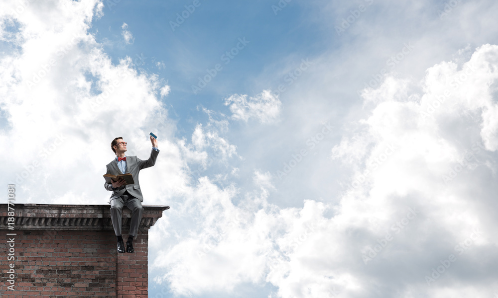 Young businessman or student studying the science on building roof