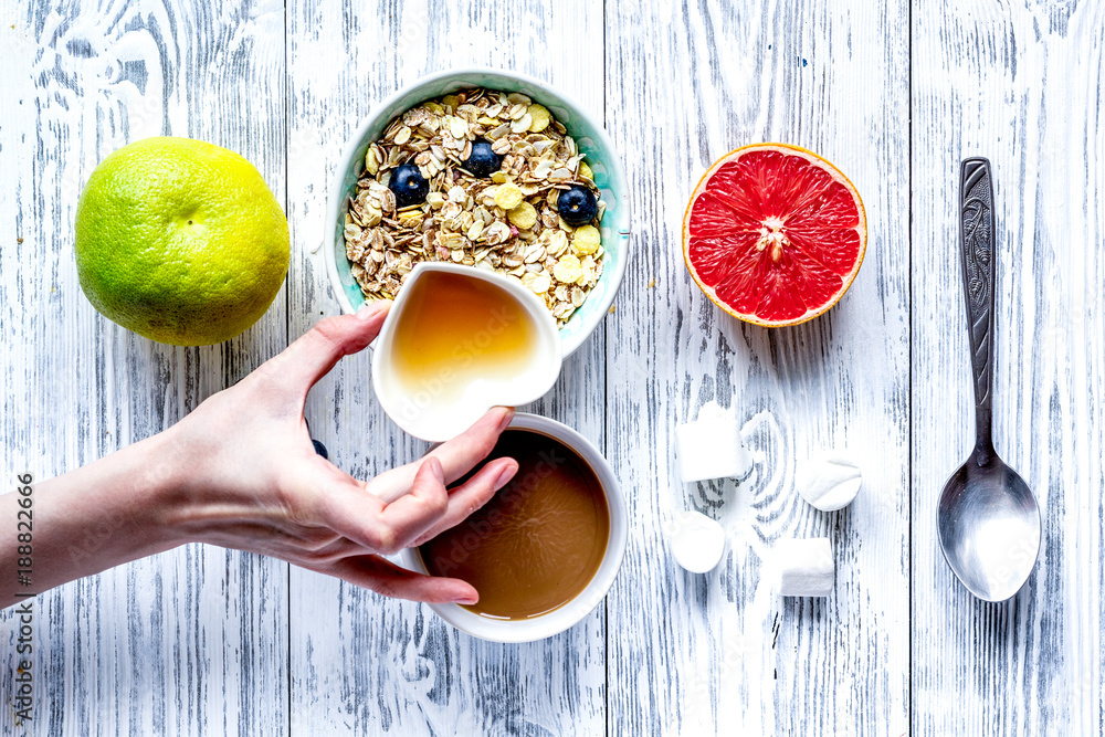 Breakfast concept with flowers on wooden background top view