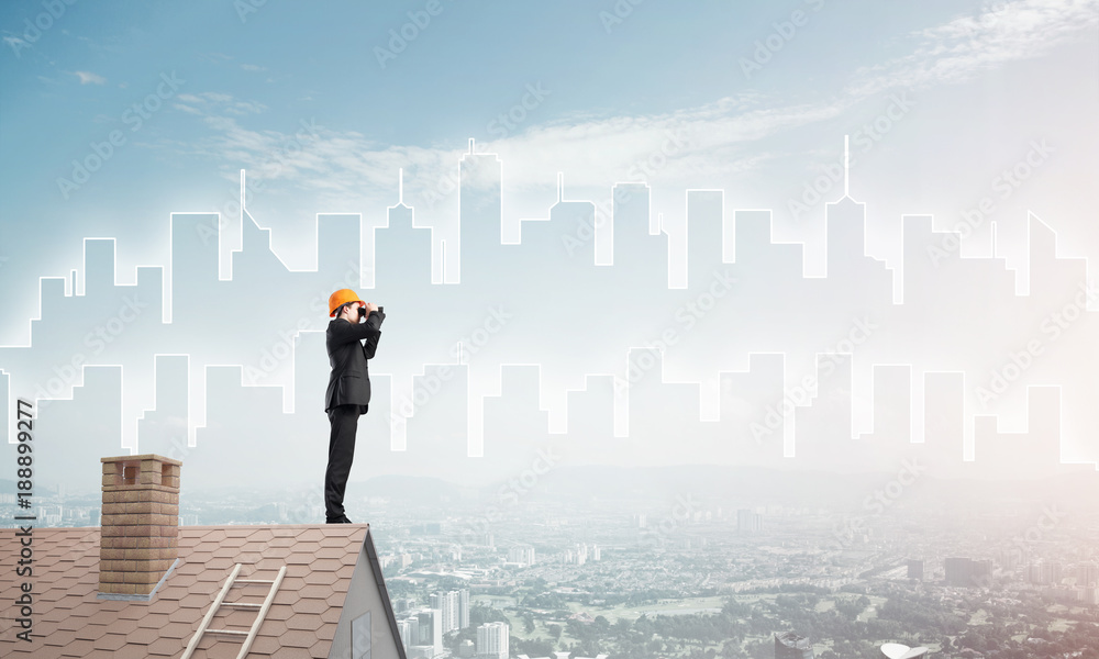 Engineer man standing on roof and looking in binoculars. Mixed media