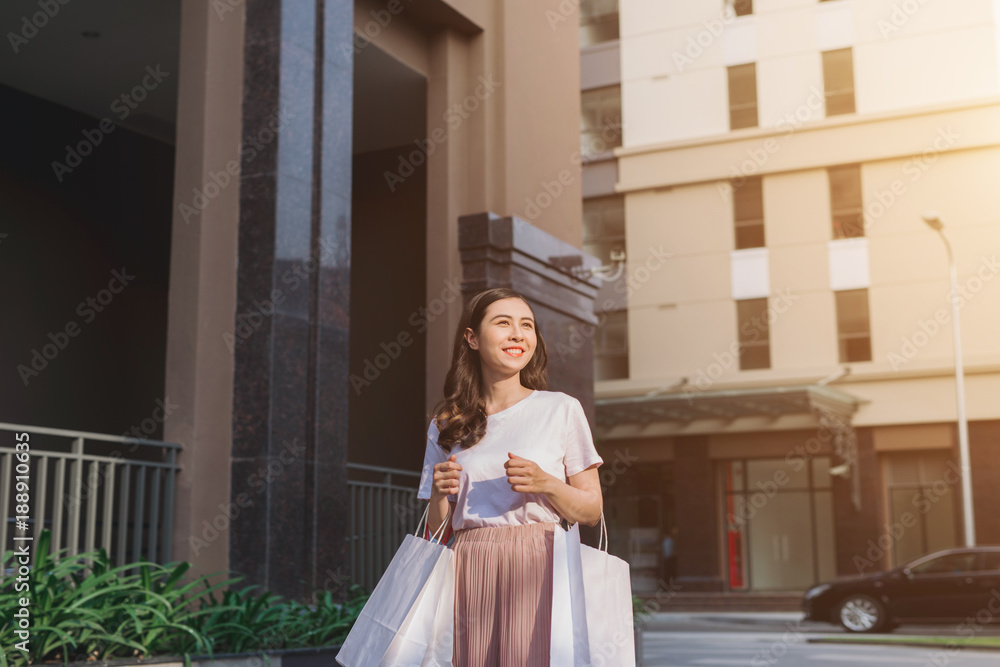 Woman with shopping bags and smiling - outdoors