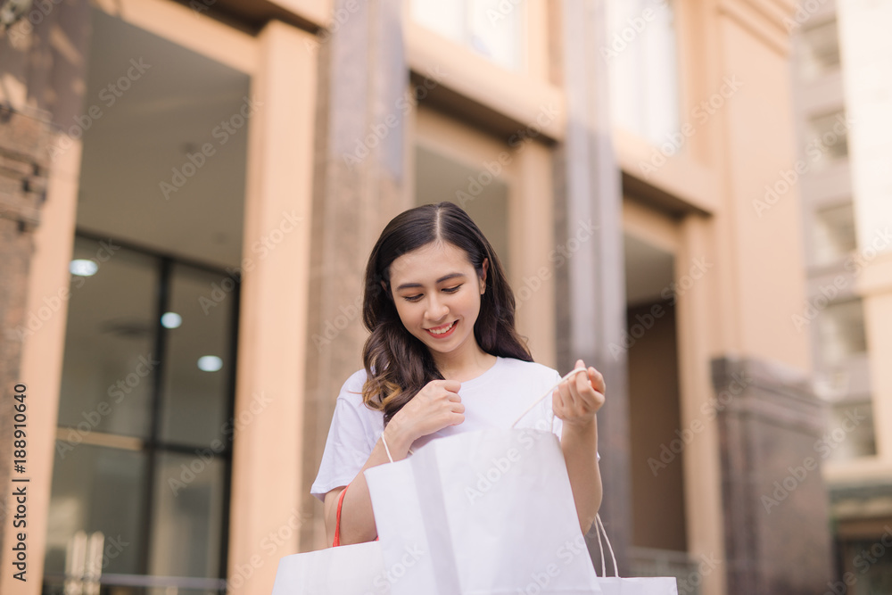 亚洲女人在时尚精品店拿着许多购物袋