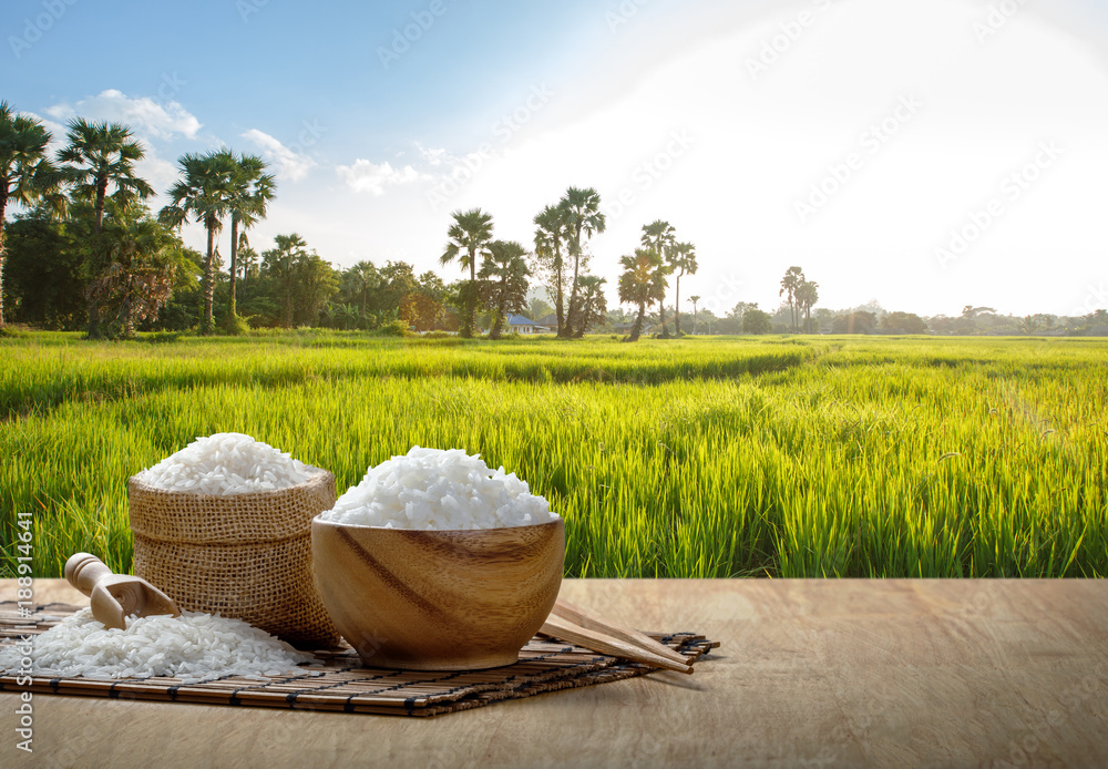 Jasmine rice and steamed rice in wooden bowl with the chopsticks on the wooden table with the planta