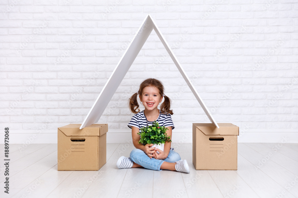 Concept of moving and housing. happy child girl with boxes