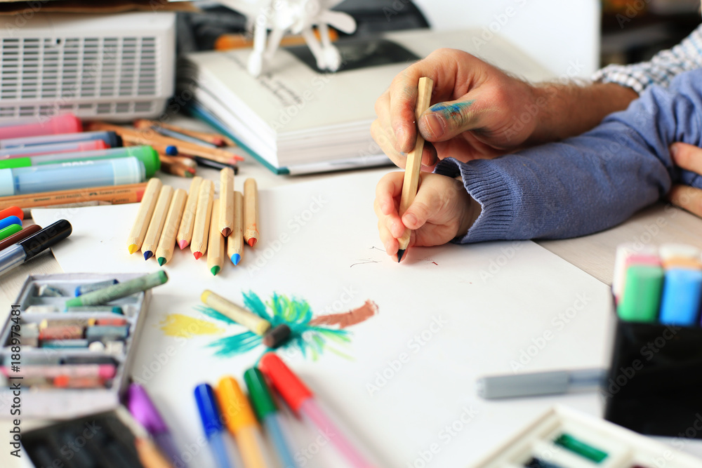 Dad teaches young son to draw pencil